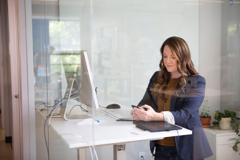 Woman on her phone in front of her computer