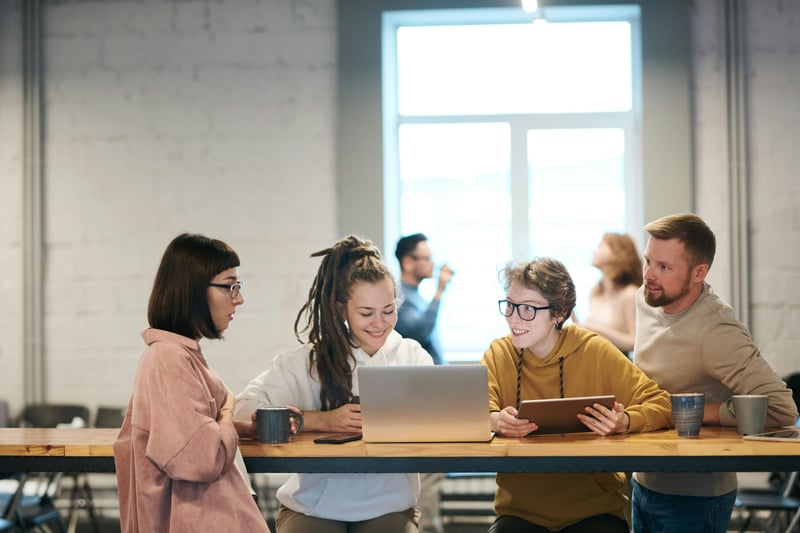 Group of colleagues discussing in front of a laptop