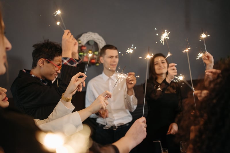 Colleagues holding sparklers and celebrating the new year