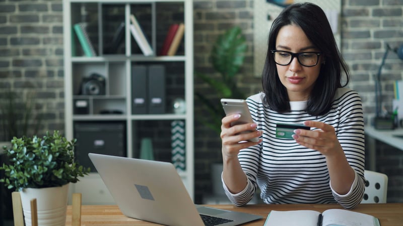 a woman researching about embedded finance through her phone